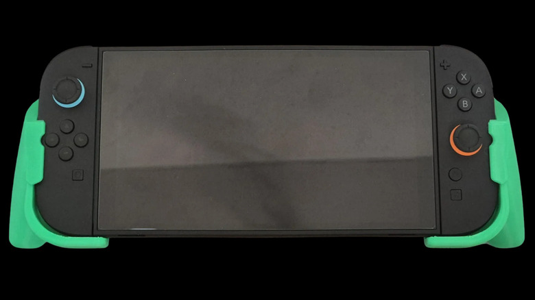 Nintendo Switch 2 console with 3D printed green grip attachments on both sides.