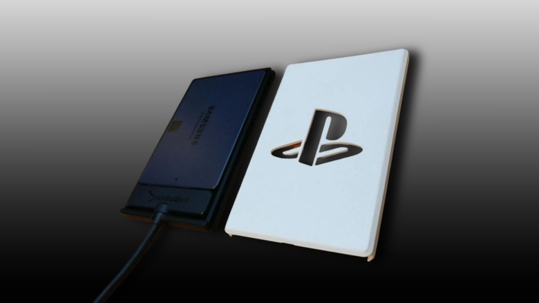 External PlayStation 5 SSD enclosure front and SATA SSD installed inside on a black and grey gradient background.