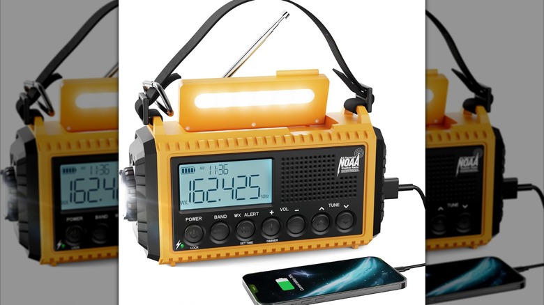 A Raynic Emergency Radio with its lights on, plugged into a phone.