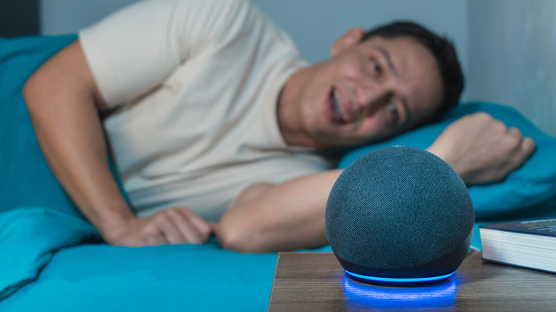 Man talking to Alexa and an Echo speaker from his bed.