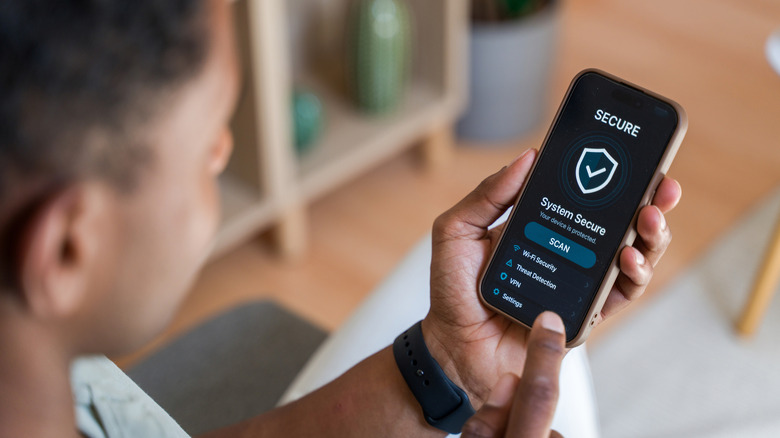 Close up of a man using a VPN for encrypted data on a mobile device.