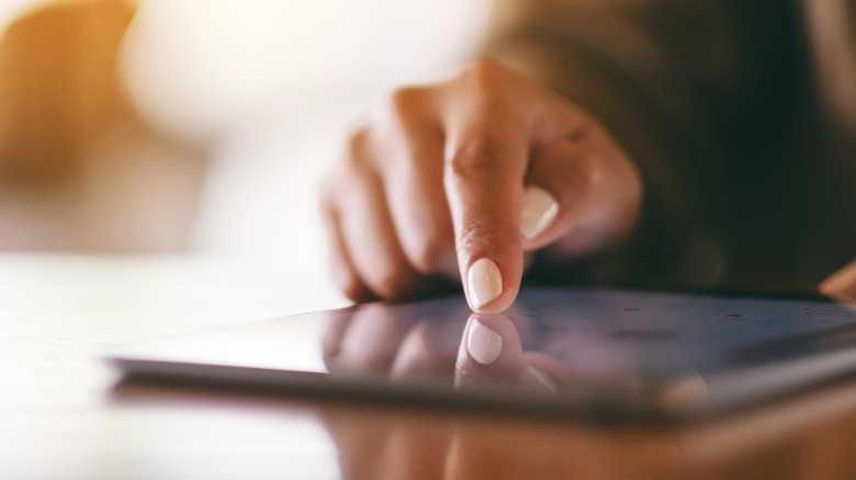 Close-up of a finger touching a tablet display