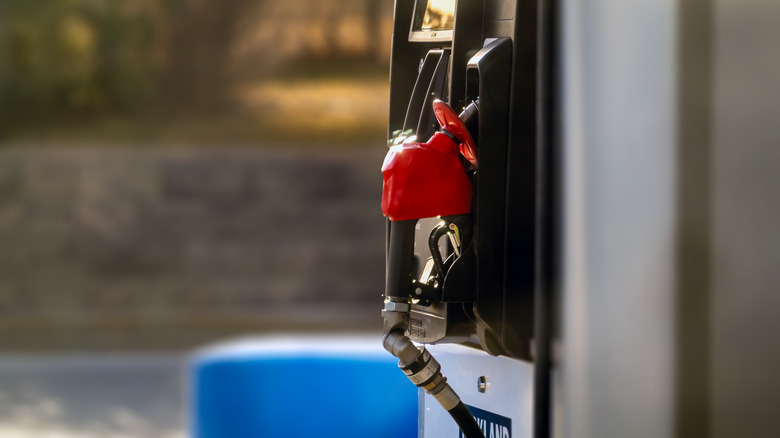 A photo of a Kirkland Signature gas gas station pump, the handle for the pump is a bright red