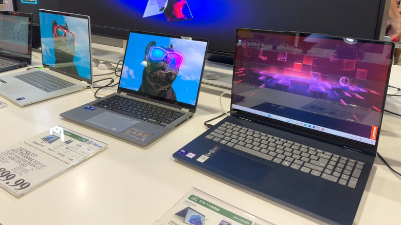 Four laptops on display inside a Costco electronics section