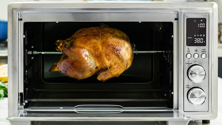 A roast chicken in a Cosori Smart Air Fryer Toaster Oven.