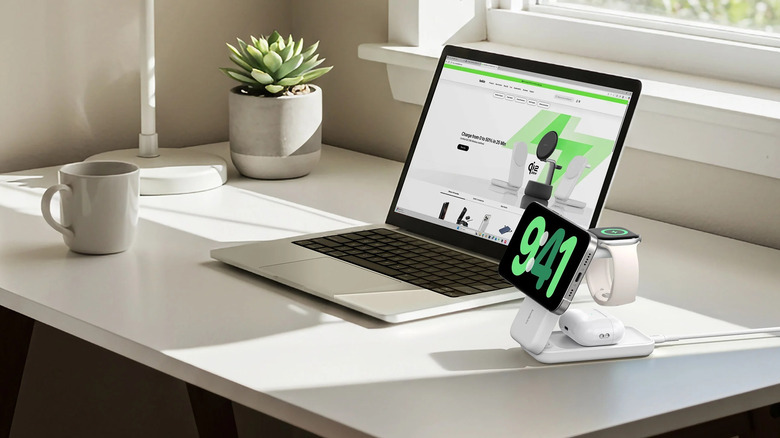 Belkin 3-in-1 Charging Stand with iPhone, Apple Watch, and AirPods charging next to laptop on table