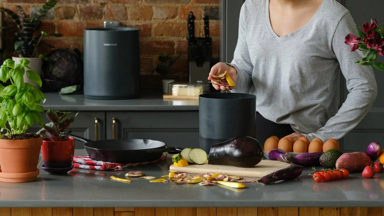 Woman putting food waste into FoodCycler Eco 3