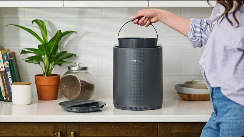 Woman putting FoodCycler Eco 3 bucket back into machine