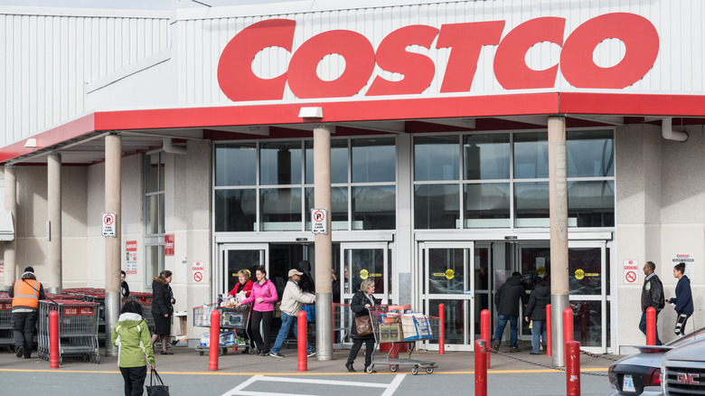 Shoppers in winter coats entering a Costco storefront