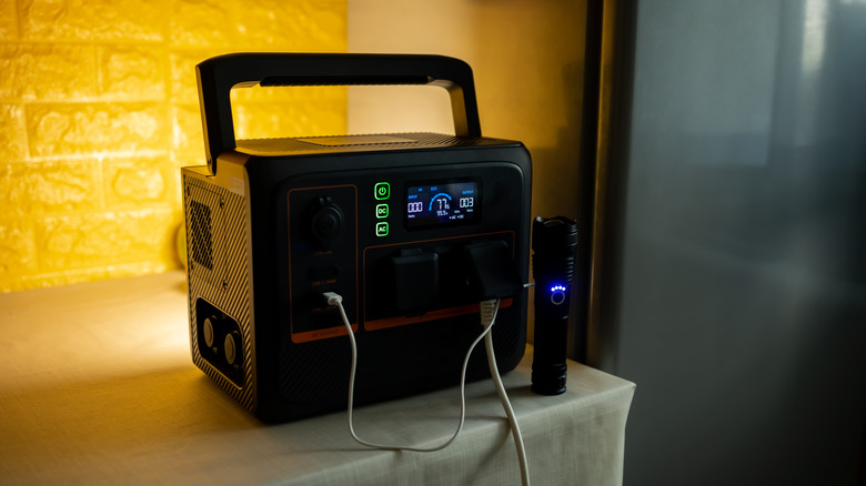 A portable power station on a counter with devices attached