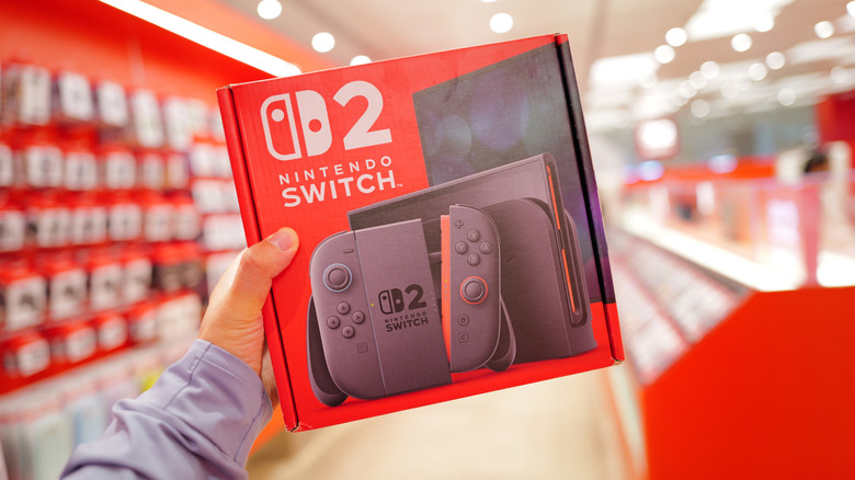 Person holding Nintendo Switch 2 box in a store