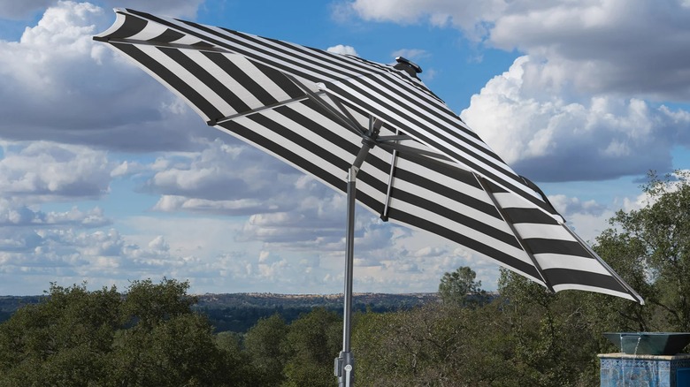The Sunvilla Solar LED Market Umbrella in a backyard.
