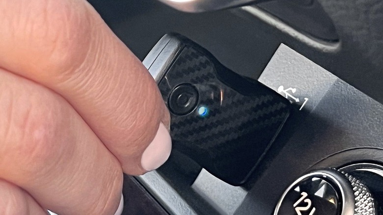 Hand plugging in Aluratek Combo Wireless Car Adapter