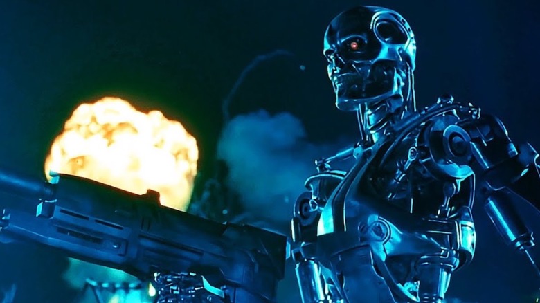 A Terminator holding a rifle with an explosion behind it in Terminator 2: Judgment Day