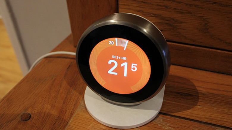 Nest thermostat showing a temperature reading on display