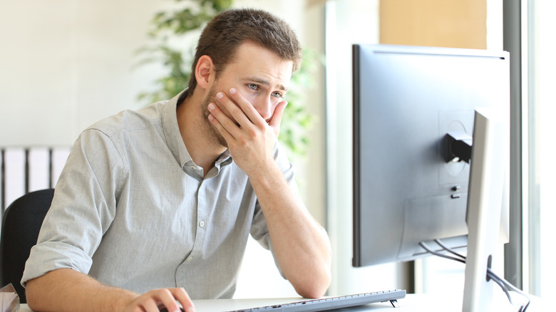 An office worker struggling with a bad desktop PC