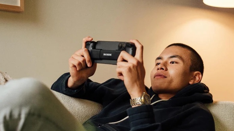 Man gaming on phone with Backbone One controller