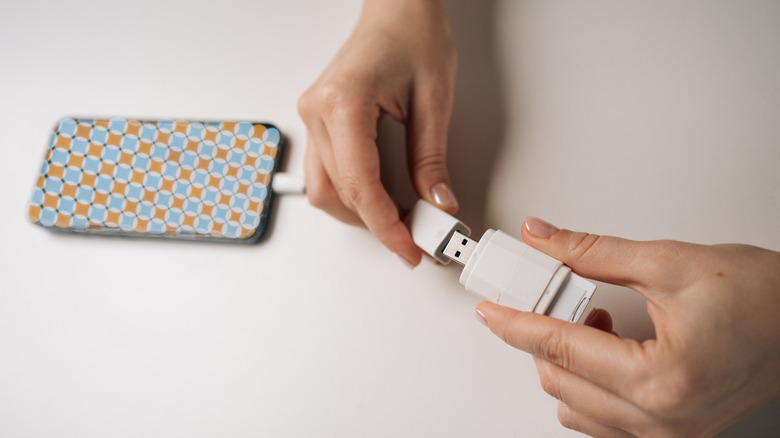 Hand plugging in a USB accessory to phone