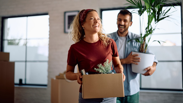 A happy couple moving into or out of a new home.