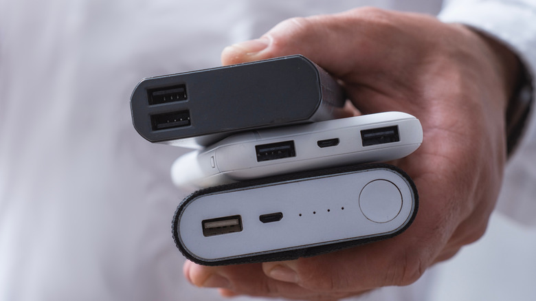 person holding three different power banks