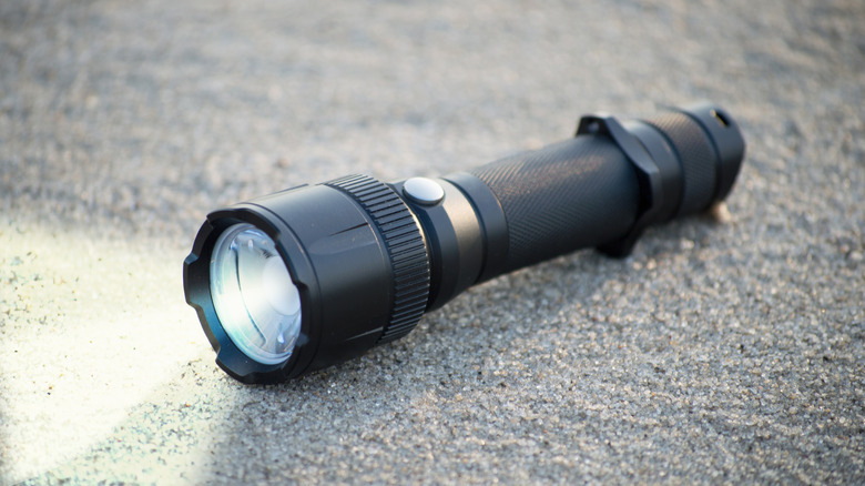 A compact flashlight placed on the ground