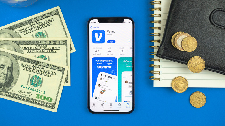A smartphone displaying an app store listing for Venmo and surrounded by currency