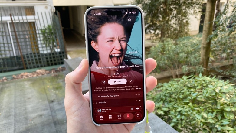 A hand holding an iPhone with Sigrid's latest album on Apple Music being displayed