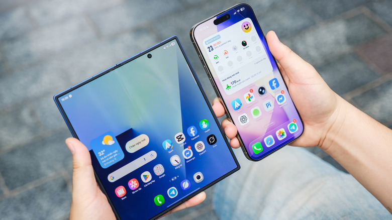 Person holding a Samsung Galaxy Fold 7 and iPhone 16 in different hands