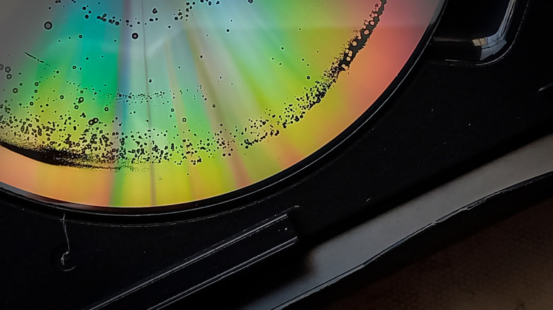 The edge of a media disc that appears to be heavily damaged in some way, there is spotted streaks throughout the disc