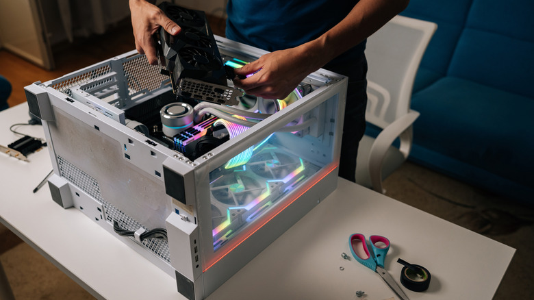 a person building a computer while laying the case on the table with parts in it