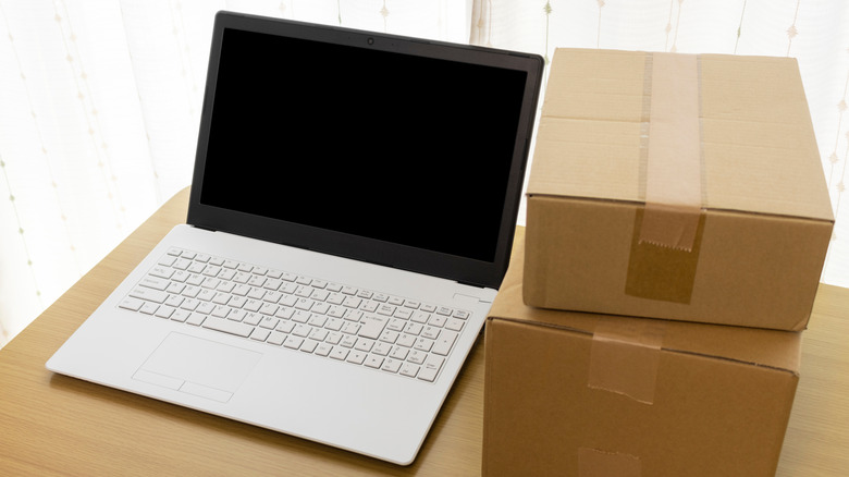 Laptop kept next to two cardboard boxes on a table