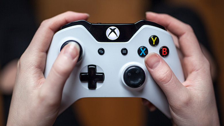 Person holding white Xbox One controller