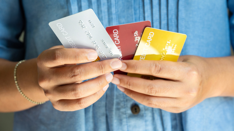Person holding several credit cards in their hand