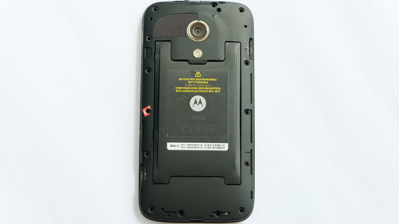 An older model Motorola Moto G phone with its back cover removed.