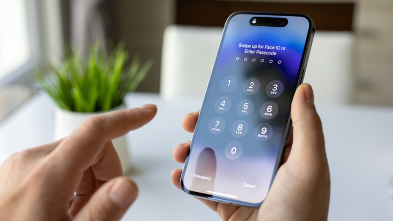 A person unlocking an iPhone with a passcode.