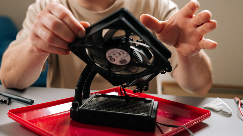 A person holding a PC cooling fan