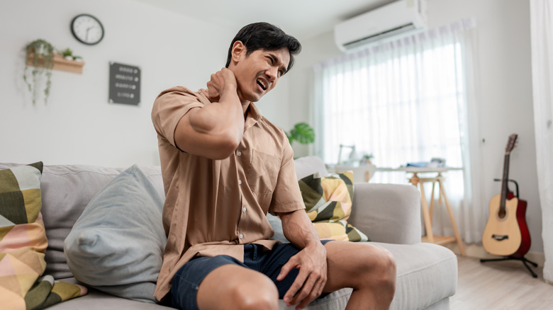 person with neck strain on couch