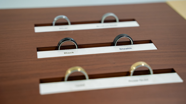 Close up of Oura Ring color options on wooden display stand