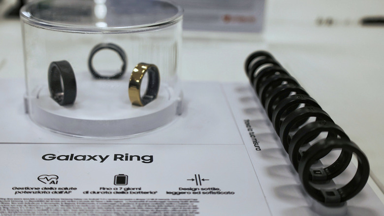 Samsung Galaxy Ring wearable device displayed on a retail presentation stand with product information and sizing rings in an electronics store.