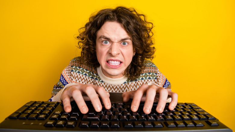Angry man typing on keyboard