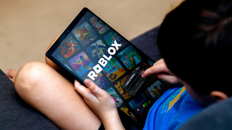 Child using a tablet to play Roblox.