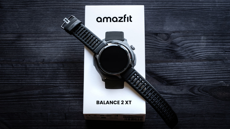 A black Amazfit Balance 2 XT with a dark screen sits on top of its white packaging