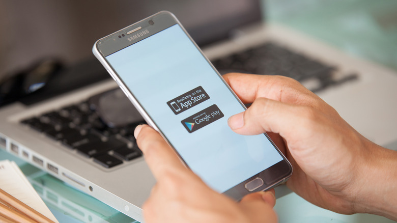 Person holding phone preparing to download an app