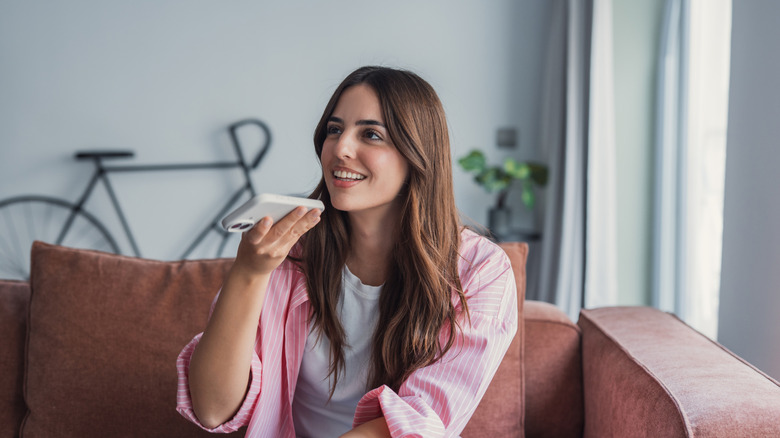 woman relaxing on comfortable sofa, sending audio message