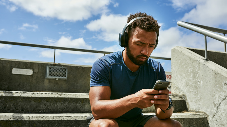 A person listening to music on a smartphone.