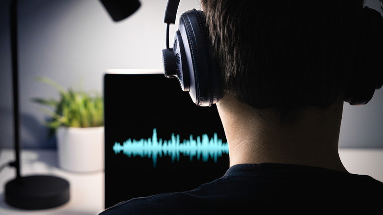 Man wearing headphones facing a screen