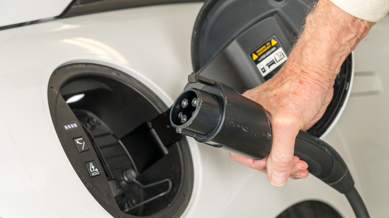 A level 2 charging cable next to an EV charging port.