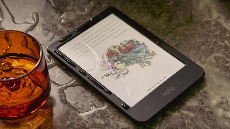 Kobo Clara Color e-reader next to a glass of water