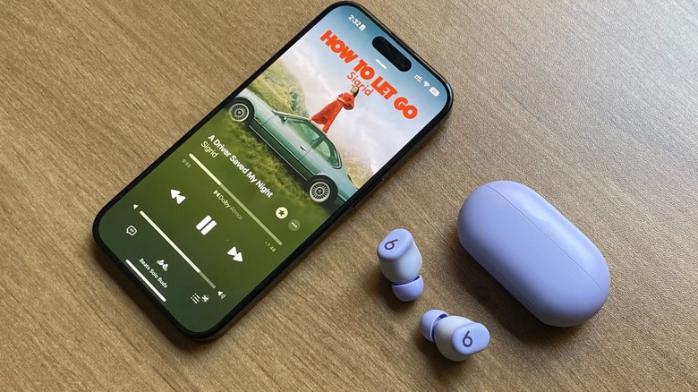 Beats Solo Buds on a table with an iPhone playing an Apple Music song