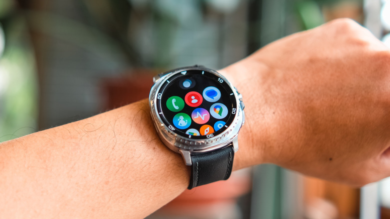 A smartwatch with its screen turned on, attached to a wrist